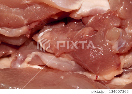 Close up of meat carcass tendons and bones from a chicken that has been carved horror blood red background food waste Close up of meat carcass tendons and bones from a chicken that has been carved horror blood red background food waste 134007363