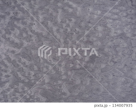 Swirling patterns on a muted gray veneer surface evoke a sense of organic movement Swirling patterns on a muted gray veneer surface evoke a sense of organic movement 134007935