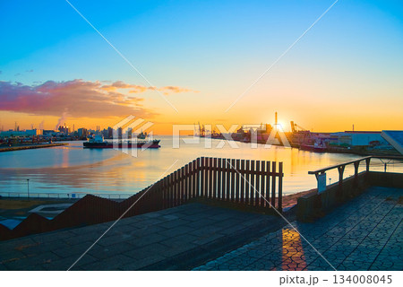 朝日が昇る仙台港と静かな水面が映す港湾風景 134008045