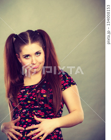 Funny teenage woman holding their stomach Funny teenage woman holding their stomach 134008153