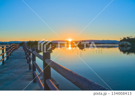 夕日が照らす松川浦桟橋と穏やかに広がる水辺の景色 夕日が照らす松川浦桟橋と穏やかに広がる水辺の景色 134008413