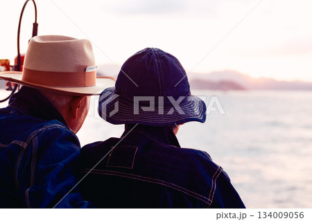 夕焼けの船上で寄り添うシニア夫婦のポートレート 134009056