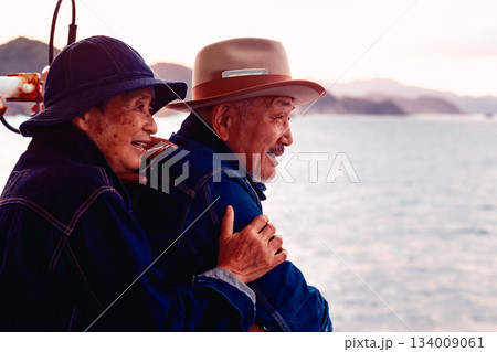 夕焼けの船上で寄り添うシニア夫婦のポートレート 134009061