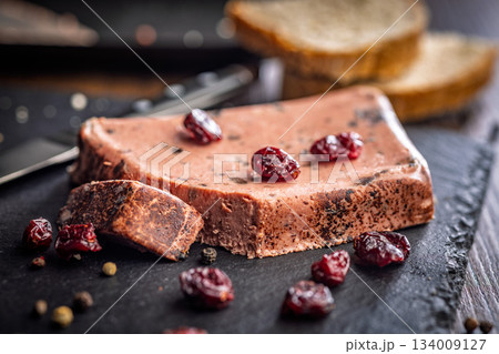 Liver pate with cranberries on stone cutting board. Liver pate with cranberries on stone cutting board. 134009127
