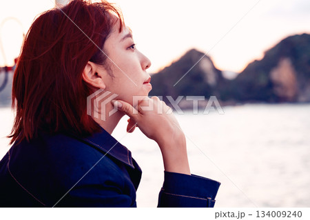 夕景の海を見つめる20代女性の後ろ姿 134009240