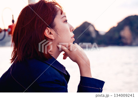 夕景の海を見つめる20代女性の後ろ姿 134009241