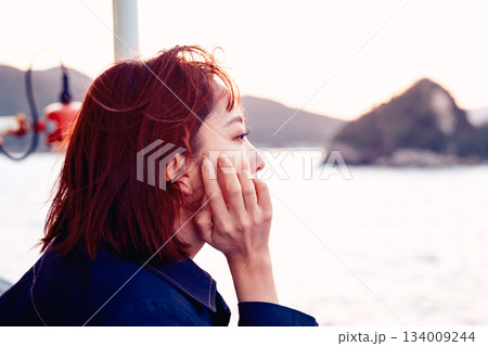 夕景の海を見つめる20代女性の後ろ姿 夕景の海を見つめる20代女性の後ろ姿 134009244