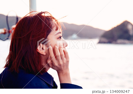 夕景の海を見つめる20代女性の後ろ姿 134009247