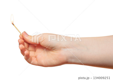 A child hand holding a thin burning match. Concept: children and fire. On a white background. 134009251