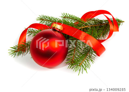 A matte Christmas tree ball with a red ribbon and a fir branch. New Year's and Christmas elements on a white background. 134009285