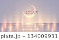 Elegant Ramadan Kareem banner with glowing crescent moon, soft pastel background and sparkling lights over a reflective surface. Peaceful, festive and modern Islamic holiday design. 134009931