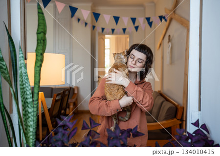 Girl ret owner holding in hands pedigree cat Devon Rex. Antistress, tactile therapy, empathy to pets Girl ret owner holding in hands pedigree cat Devon Rex. Antistress, tactile therapy, empathy to pets 134010415