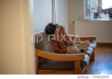 Depressed pet owner feeling lonely, stressed sitting at home with friend, companion cat devon rex Depressed pet owner feeling lonely, stressed sitting at home with friend, companion cat devon rex 134010435