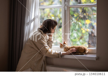 Outcast by friends teen girl feeling lonely, stresses, depressed stroking cat for emotional support  134010611