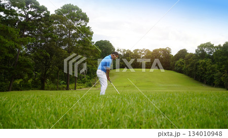 Golfer playing golf in the evening golf course, on sun set evening time. 134010948