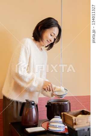 ホテルでご飯をよそう女性 134011327