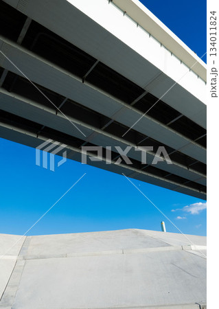 青空の下の高速道路と堤防 134011824