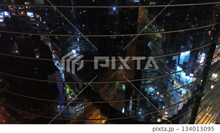 Skycrapper with reflection in glass busy traffic at night Skycrapper with reflection in glass busy traffic at night 134013095