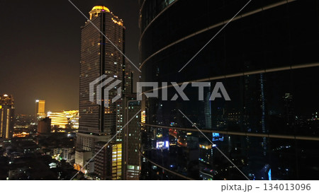 Skycrapper with reflection in glass busy traffic at night Skycrapper with reflection in glass busy traffic at night 134013096