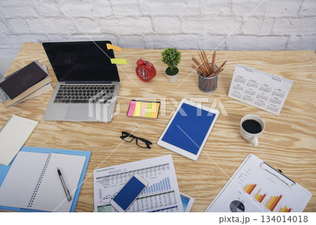Meeting room Office laptop business financial document chart , graph on wooden table with coffee cup. Flat lay notebook computer laptop on office desk. No people business graph chart on meeting table Meeting room Office laptop business financial document chart , graph on wooden table with coffee cup. Flat lay notebook computer laptop on office desk. No people business graph chart on meeting table 134014018