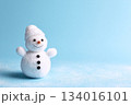 Cute snowman figure with a warm smile and cozy hat, set against a light blue background to celebrate winter festivities during the holiday season 134016101