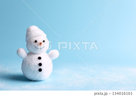 Cute snowman figure with a warm smile and cozy hat, set against a light blue background to celebrate winter festivities during the holiday season Cute snowman figure with a warm smile and cozy hat, set against a light blue background to celebrate winter festivities during the holiday season 134016101