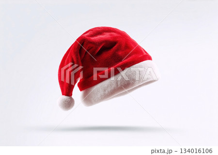 Festive red Christmas hat with white trim floating against a simple background showcasing holiday spirit and seasonal decorations 134016106