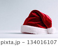 Classic red Santa hat resting on a plain background, evoking holiday spirit and festive celebrations during the winter season 134016107