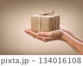 Present wrapped in burlap held gently in two hands, symbolizing the spirit of giving during special occasions and celebrations 134016108
