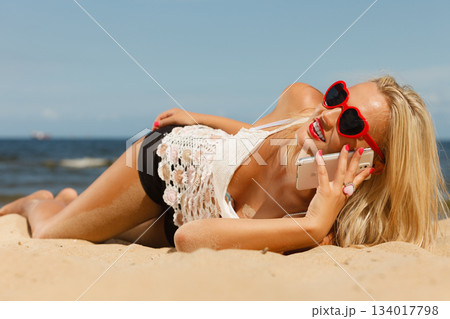 Girl on beach with phone. 134017798