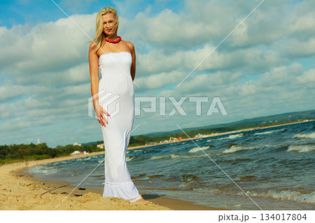 Female tourist walking on beach. 134017804