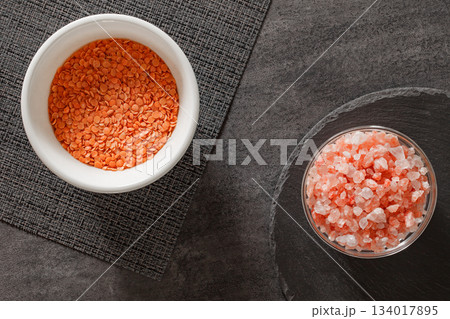 raw red lentils in bowl and pink Himalayan salt, top view 134017895