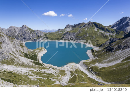 Lunersee artificial lake in Ratikon Alps showcases clear blue waters and steep mountain ranges in Vorarlberg Austria on a sunny day 134018240