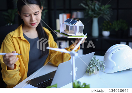 Beautiful engineer working in office design eco friendly and sustainable living home. Beautiful engineer working in office design eco friendly and sustainable living home. 134018645