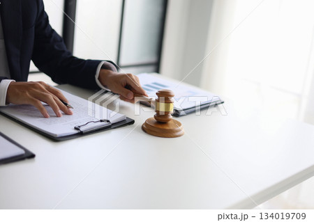 Legal counsel reading contract paperwork to finalize a legal agreement. Concepts for legal counsel, judicial authority, and the finality of a decision or agreement. 134019709