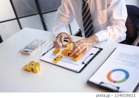 Businessman investing in gold to diversify portfolios hedge against inflation and currency depreciation. Businessman investing in gold to diversify portfolios hedge against inflation and currency depreciation. 134019811