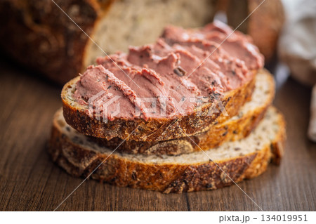 Pate on a slice of bread on wooden table. 134019951