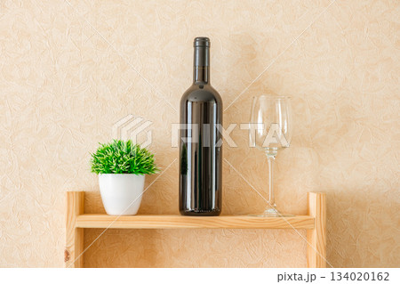bottle of wine, glass and flower on shelf 134020162