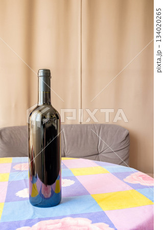 one bottle of wine on table with flowered tablecloth 134020265