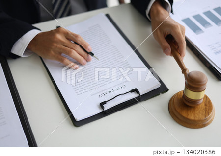Legal counsel reading contract paperwork to finalize a legal agreement.  134020386