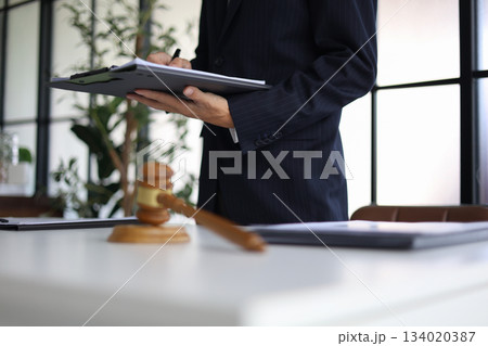 Legal counsel reading contract paperwork to finalize a legal agreement. Legal counsel reading contract paperwork to finalize a legal agreement. 134020387