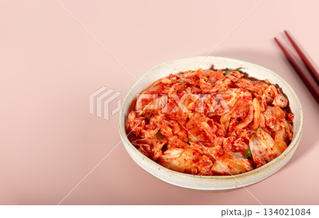 Spicy Korean fermented cabbage with chopsticks on pink background. Probiotic food concept. Copy space. Banner Spicy Korean fermented cabbage with chopsticks on pink background. Probiotic food concept. Copy space. Banner 134021084