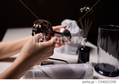 Preparing blender on kitchen counter, Scene shows detailed process of assembling immersion blender, Cozy kitchen scene of hands carefully putting together blending device 134022100