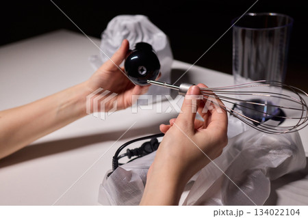 Preparing blender on kitchen counter, Scene shows detailed process of assembling immersion blender, Cozy kitchen scene of hands carefully putting together blending device 134022104