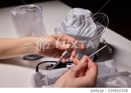 Preparing blender on kitchen counter, Scene shows detailed process of assembling immersion blender, Cozy kitchen scene of hands carefully putting together blending device 134022108