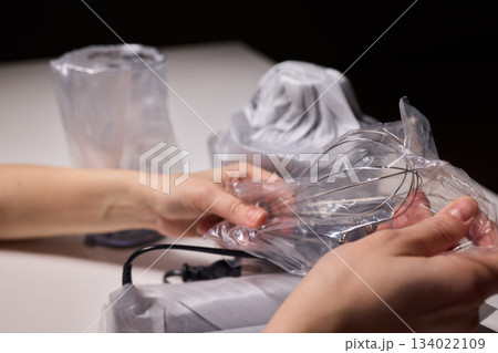 Preparing blender on kitchen counter, Scene shows detailed process of assembling immersion blender, Cozy kitchen scene of hands carefully putting together blending device 134022109