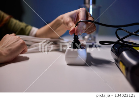 Safe plug connection demonstration, Careful connection of electrical device to power source, Demonstration of proper plugin procedure emphasizing safety and correct technique 134022125