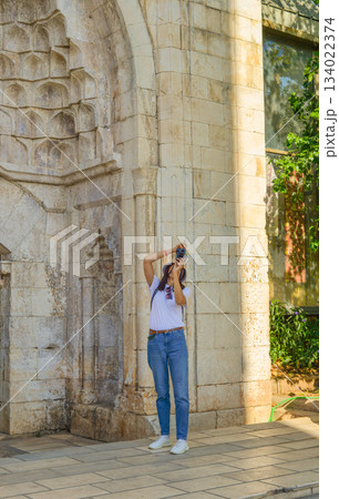 A girl tourist takes photographs of Hadrian's Gate, Antalya,Turkey 134022374