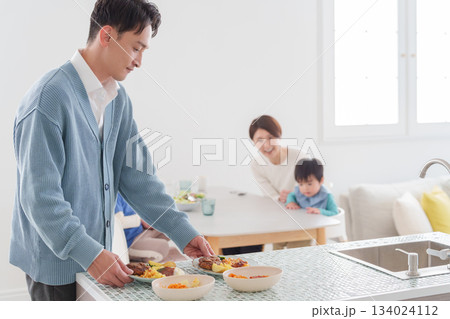 家族で食べる料理を配膳する父親 家族で食べる料理を配膳する父親 134024112