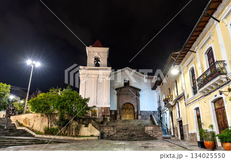 San Blas Church stands near the historic center of Quito, Ecuador. Colonial white Catholic church features stone entrance and bell tower illuminated under night sky San Blas Church stands near the historic center of Quito, Ecuador. Colonial white Catholic church features stone entrance and bell tower illuminated under night sky 134025550